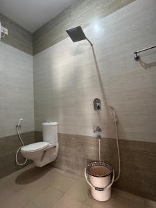 a bathroom with a toilet and a shower at Zen Studio Apartment in kāraikāl