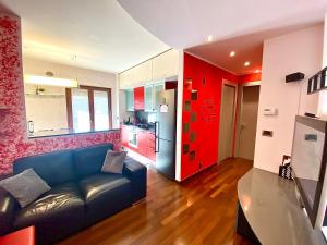 - un salon avec un canapé bleu et des armoires rouges dans l'établissement Red House, à Monfalcone