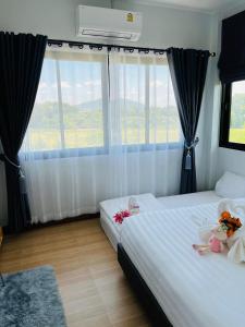 una camera con due letti e una finestra di Cher Cher Pool Villa a Ban Chang