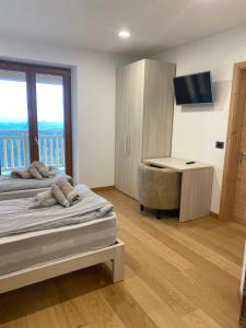 a bedroom with two beds and a desk and a television at MASO CLENA in Balbido-rango
