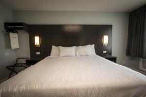 een groot wit bed in een hotelkamer bij Envi Boutique Hotel in Henderson