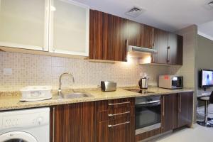 a kitchen with wooden cabinets and a sink at New Arabian - GOLDCREST in Dubai