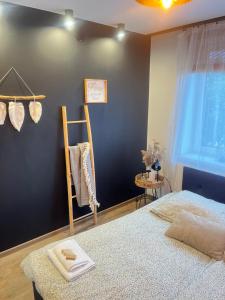a bedroom with a black wall and a bed at Nowoczesny mały Apartament nr 3 nad jeziorem in Orzysz