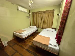 a room with two beds and a window at DonMueang Boutique House DonMueang Airport in Bangkok