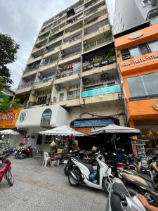 un grupo de motocicletas estacionadas frente a un edificio en DucTaigallery's Apt&Center in Saigon, en Ho Chi Minh