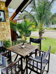 een houten tafel en stoelen op een patio met palmbomen bij HERMOSA Y COMODA CASA " En condominio Privado " in Santa Cruz de la Sierra