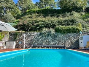 uma piscina em frente a uma parede de pedra em Villa Turchese em Sulzano
