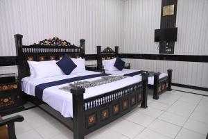 a bedroom with two beds with white and blue pillows at Hotel Serina Inn in Kalar Goth