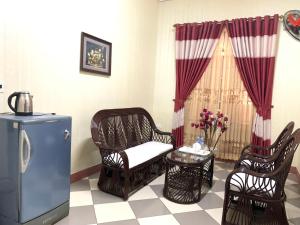 Quang TriにあるKHÁCH SẠN PHỤNG HOÀNGのリビングルーム(椅子、テーブル、冷蔵庫付)