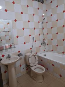 La salle de bains est pourvue de toilettes, d'un lavabo et d'une baignoire. dans l'établissement KHÁCH SẠN PHỤNG HOÀNG, à Quang Tri