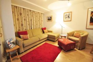 ツェルマットにあるハウス アルミナ - アパートメント エドワードのリビングルーム(ソファ、椅子、赤い敷物付)