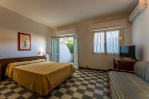 a bedroom with a bed and a tv and a couch at Giannella Beach Residence Apartment in Giannella