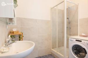 La salle de bains est pourvue d'un lavabo et d'un lave-linge. dans l'établissement Trieste Centre - Reserved Parking & Wi-Fi, à Trieste