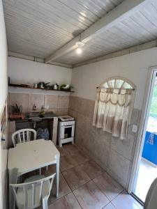 eine kleine Küche mit einem Tisch und einem Herd in der Unterkunft Chalés & Casas Shallon Adonai in Visconde De Maua