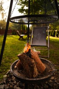 a fire pit with a piece of meat on fire at Stacja Alpaka Duży Domek nad Zalewem Chańcza in Raków