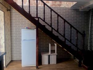a staircase with a white refrigerator next to a brick wall at Бархат in Cholpon-Ata