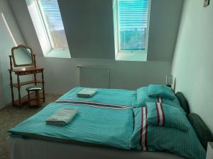 FüzérradványにあるKorona Panzióのベッドルーム(ベッド1台、椅子、鏡付)