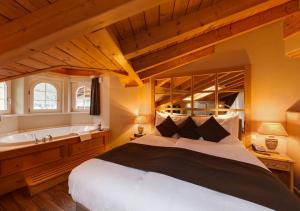 una camera da letto con un letto grande e una vasca da bagno di Hotel Albatros a Zermatt