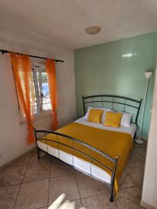 a bedroom with a bed with orange curtains and a window at Olive Garden Apartments in Poljica