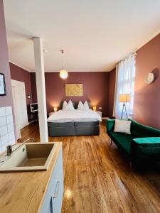 a large room with a bed and a couch at Pension alter Fehrbelliner Bahnhof in Fehrbellin