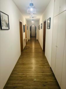 a hallway with a long corridor with white walls and wood floors at Hotel & Restaurant Olio é Pane in Enzklösterle