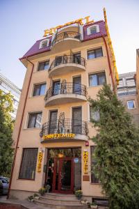 um edifício amarelo alto com uma porta vermelha em Hotel Cantemir em Bucareste