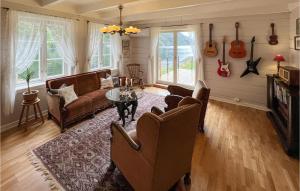 sala de estar con sofá y sillas y guitarras en la pared en 5 Bedroom Amazing Home In Suldalsosen, en Suldalsosen