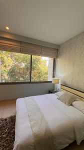 a bedroom with a large bed and a large window at Abdoun Falls Luxury Apartment in Amman