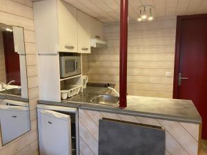 una pequeña cocina con fregadero y microondas en Studio indépendant au calme à Biarritz, en Biarritz