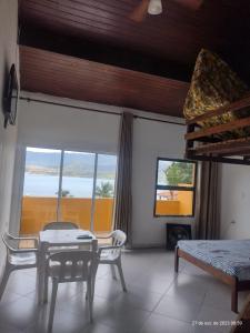 a room with a table and chairs and a window at Chalé do Saulo in Ilhabela