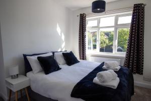1 dormitorio con 1 cama grande y toallas. en Fully renovated spacious home, Sleeps 5, en Grantham