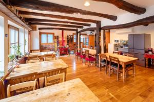 a dining room with wooden tables and chairs at Pension Eastmountain Hakuba in Hakuba