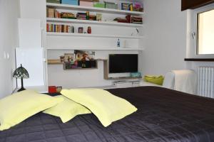 1 dormitorio con 1 cama grande con almohadas amarillas en Il giardino delle ortensie, en Vogogna