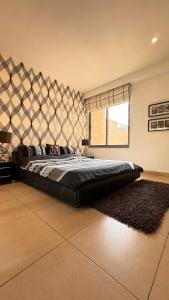 a bedroom with a large bed with a large headboard at Abdoun Falls Luxury Apartment in Amman