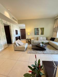 Abdoun Falls Luxury Apartment في عمّان: غرفة معيشة كبيرة مع كنب وطاولة