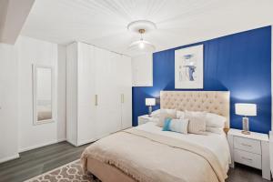 a bedroom with blue walls and a large bed at Luxury 1 Bed Retreat With Free Parking - FREE NETFLIX & WIFI in Chatham