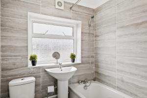 uma casa de banho com um lavatório, um WC e uma janela. em Luxury 1 Bed Retreat With Free Parking - FREE NETFLIX & WIFI em Chatham