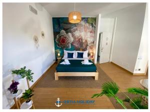 une chambre avec un lit avec un tableau sur le mur dans l'établissement Ostia Holiday Piazzetta Capri, à Lido di Ostia