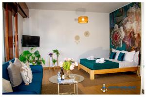 un salon avec un lit et un canapé bleu dans l'établissement Ostia Holiday Piazzetta Capri, à Lido di Ostia