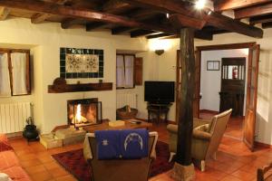 sala de estar con chimenea y TV en Casa del Recaudador, en Quintanilla de Onsoña