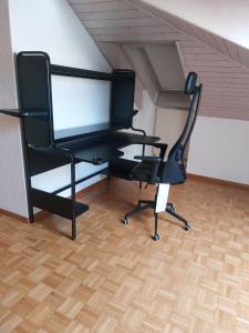 弗里堡的住宿－2p1/2 proche de la gare，阁楼上一张带椅子的黑色电脑桌