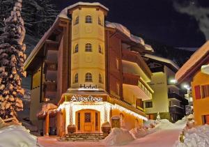 un gran edificio con luces de Navidad delante de él en Hotel Albatros, en Zermatt