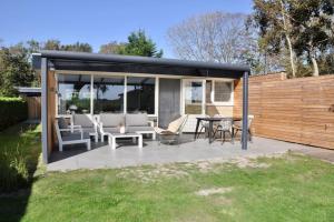 - un pavillon avec une table et des chaises dans la cour dans l'établissement Wildrijk 104, à Sint Maartensvlotbrug