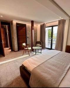 a bedroom with a large bed and a table at Hôtel Restaurant & Spa Les Planets in Les Rasses
