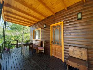 a porch of a wooden cabin with a table and a bench at Delta tigre "Peperina Gambado" in Tigre