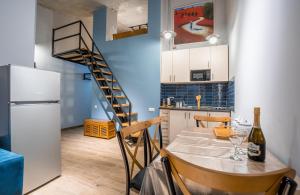 a kitchen with a dining table and a spiral staircase at Roshka 2 BD Apart 501 in Gudauri