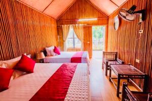um quarto com duas camas e um banco num quarto em Tam Coc Bungalow em Ninh Binh