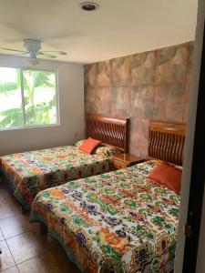 - une chambre avec 2 lits et une fenêtre dans l'établissement FINCA LA VIRGEN DE PIEDRA ATLIXCO, à Atlixco