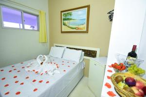 a bedroom with a bed with a bowl of fruit at Pousada Solmar in Japaratinga