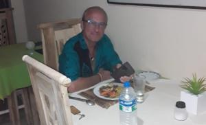 mężczyzna siedzący przy stole z talerzem jedzenia w obiekcie Victory colombo w Kolombo